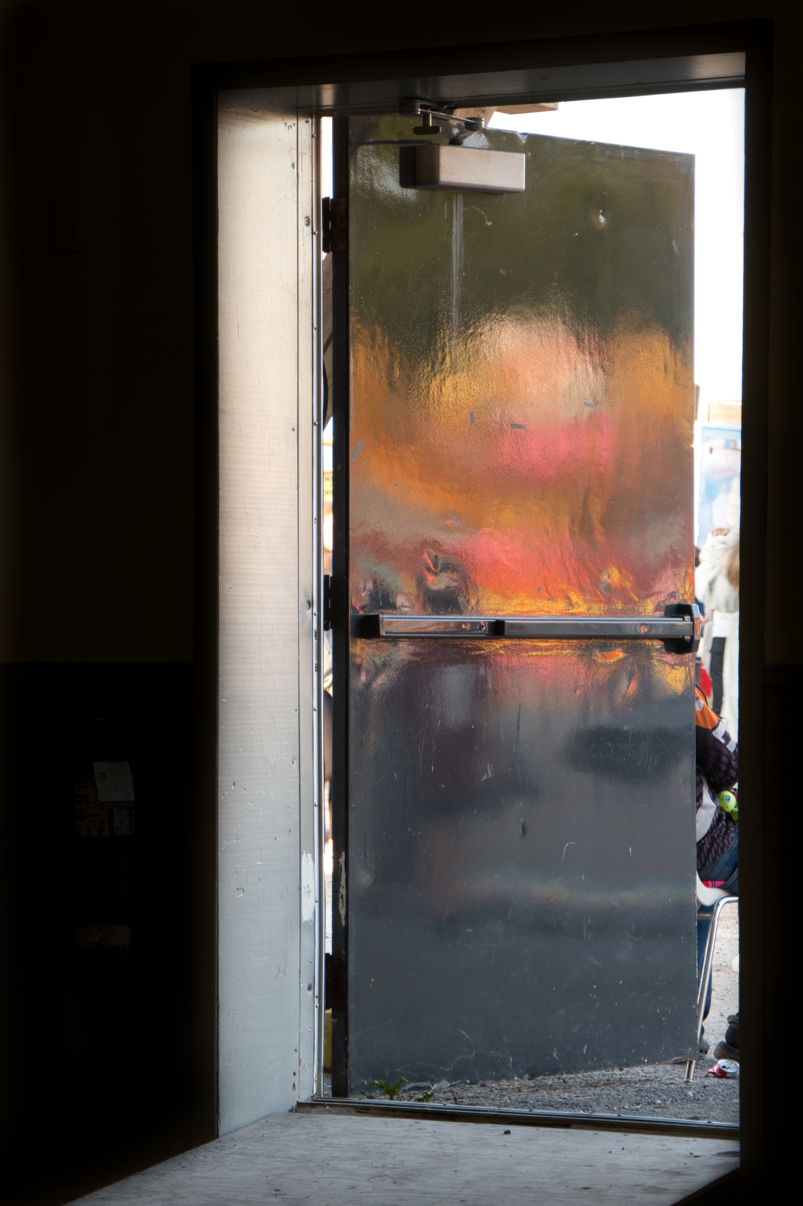 fair lights reflecting off the back of doorway viewed from inside a dark building
