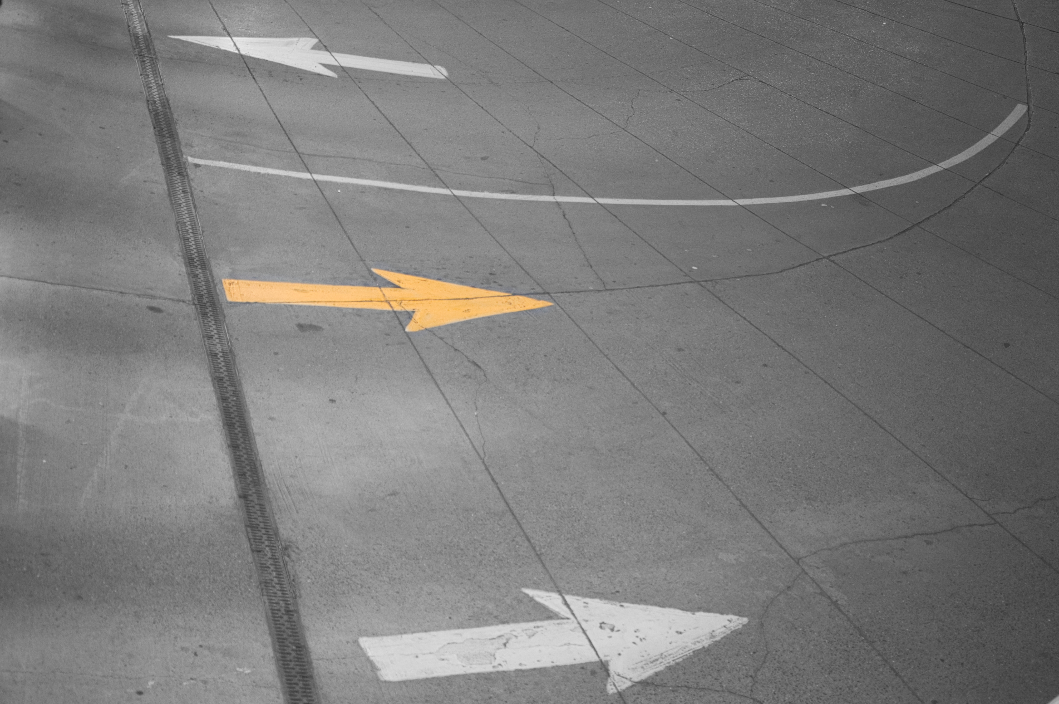 three traffic arrows painted on concrete pointing left and right