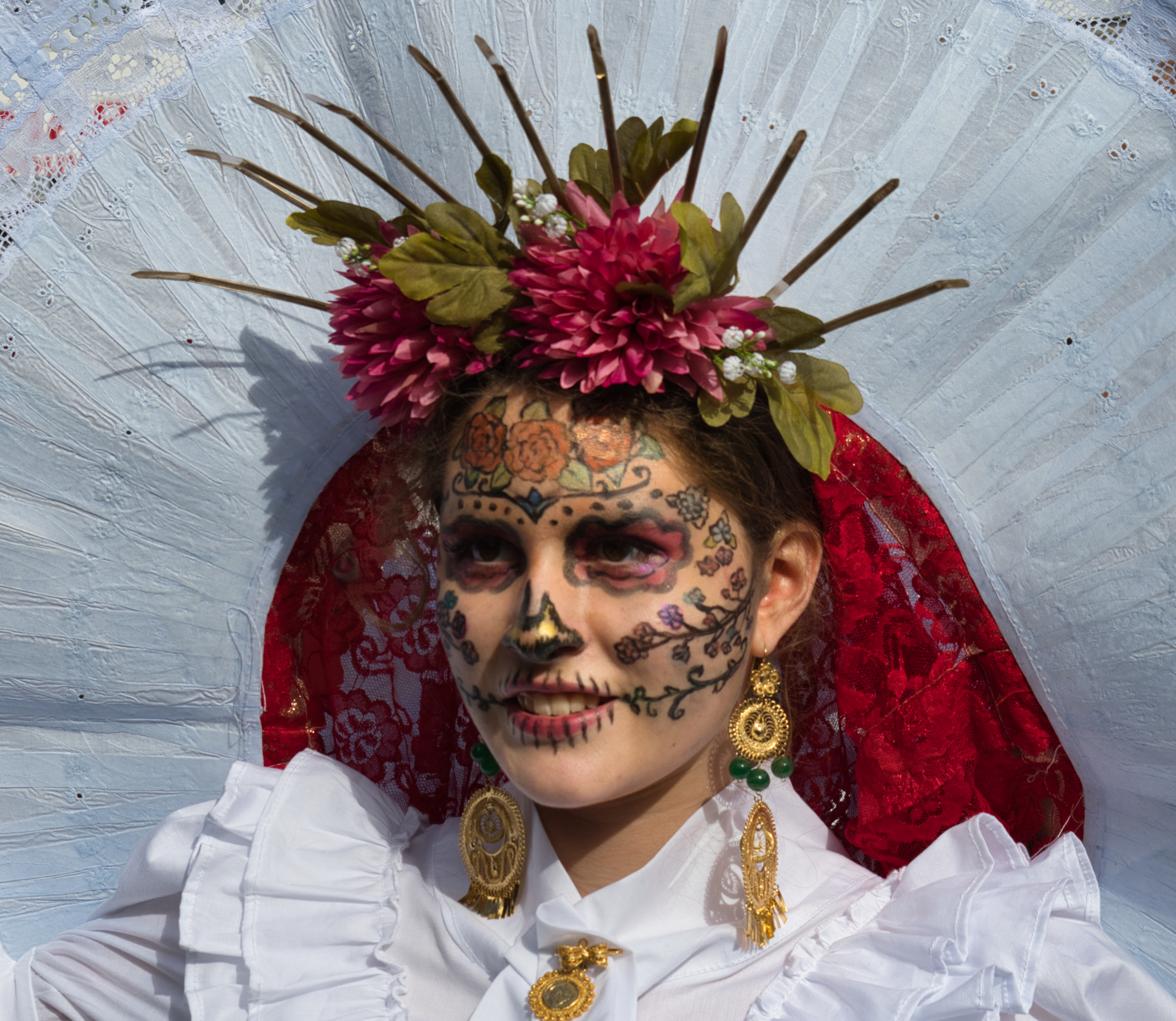 a woman in traditional makeup and clothing for the Day of the Dead Festival