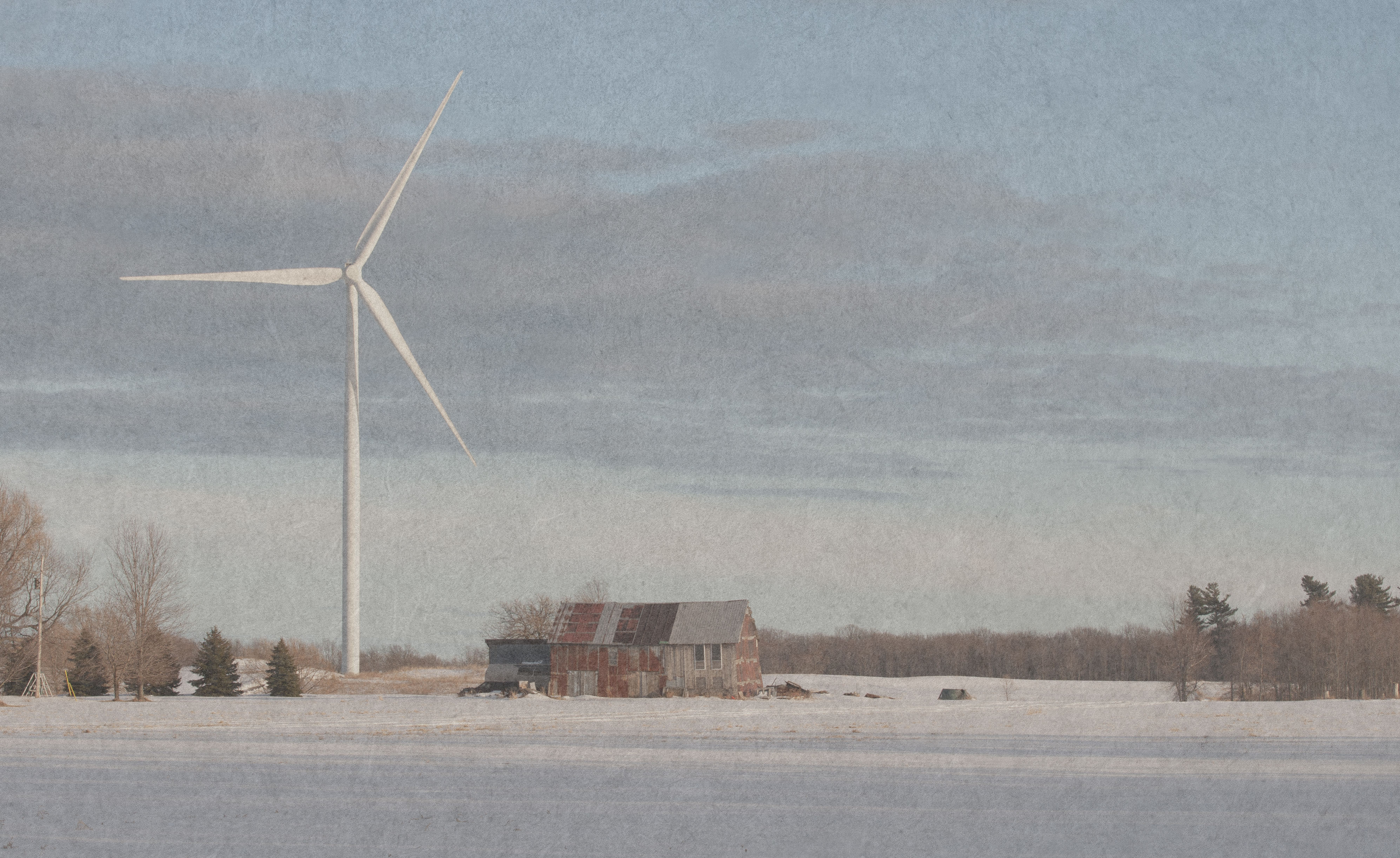 A wind turbine looms over an old barn.