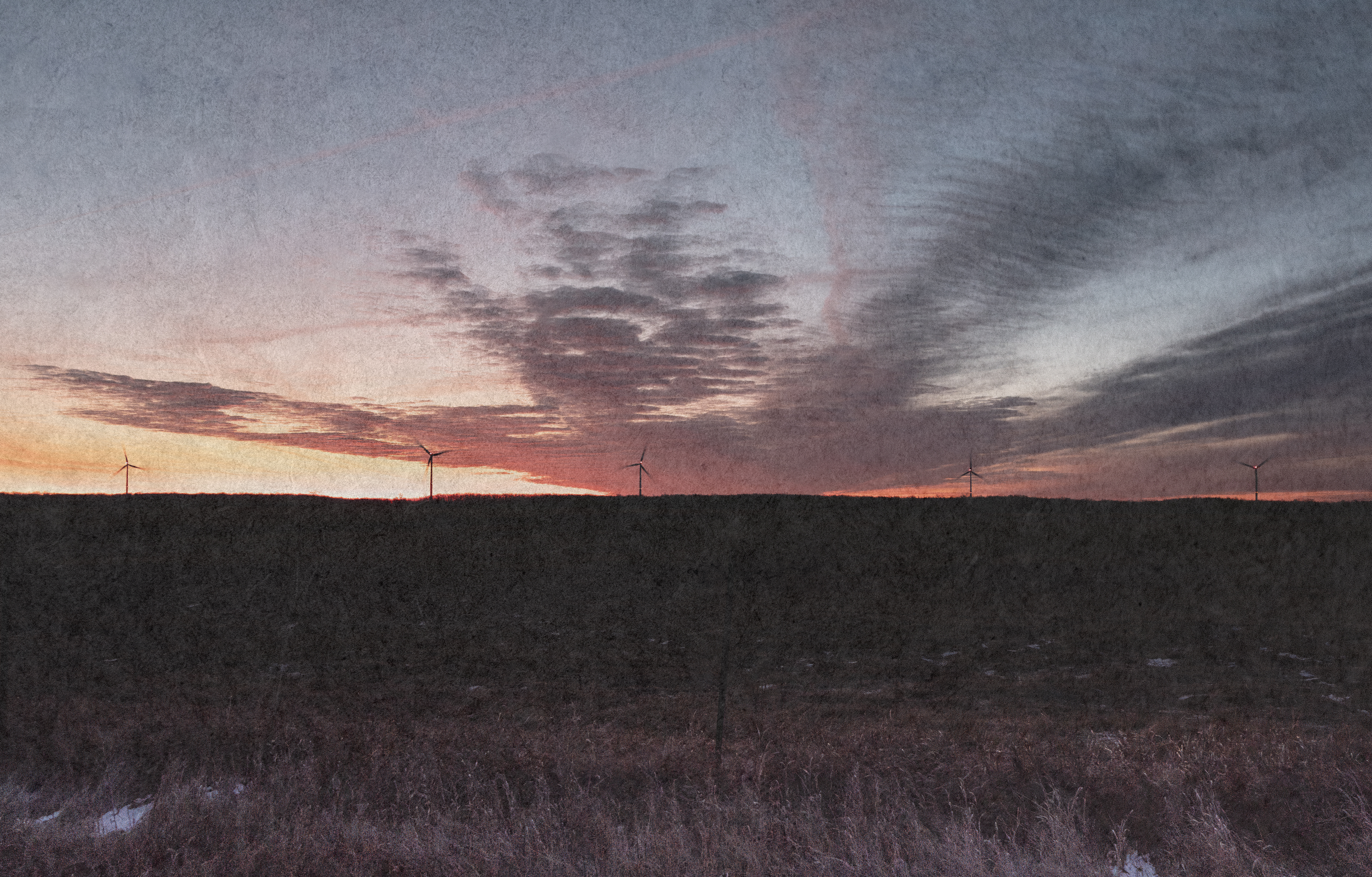 Wind turbines in the distance with a spectacular sunset.